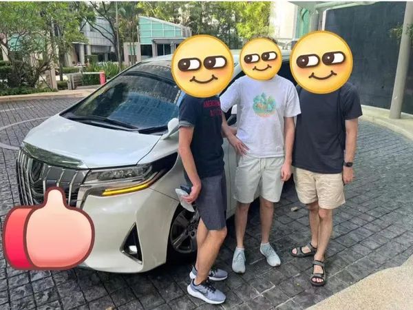 Customers posing with a white Toyota Alphard chauffeur van