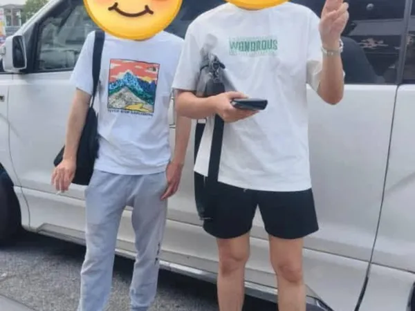 Two customers posing beside a white van