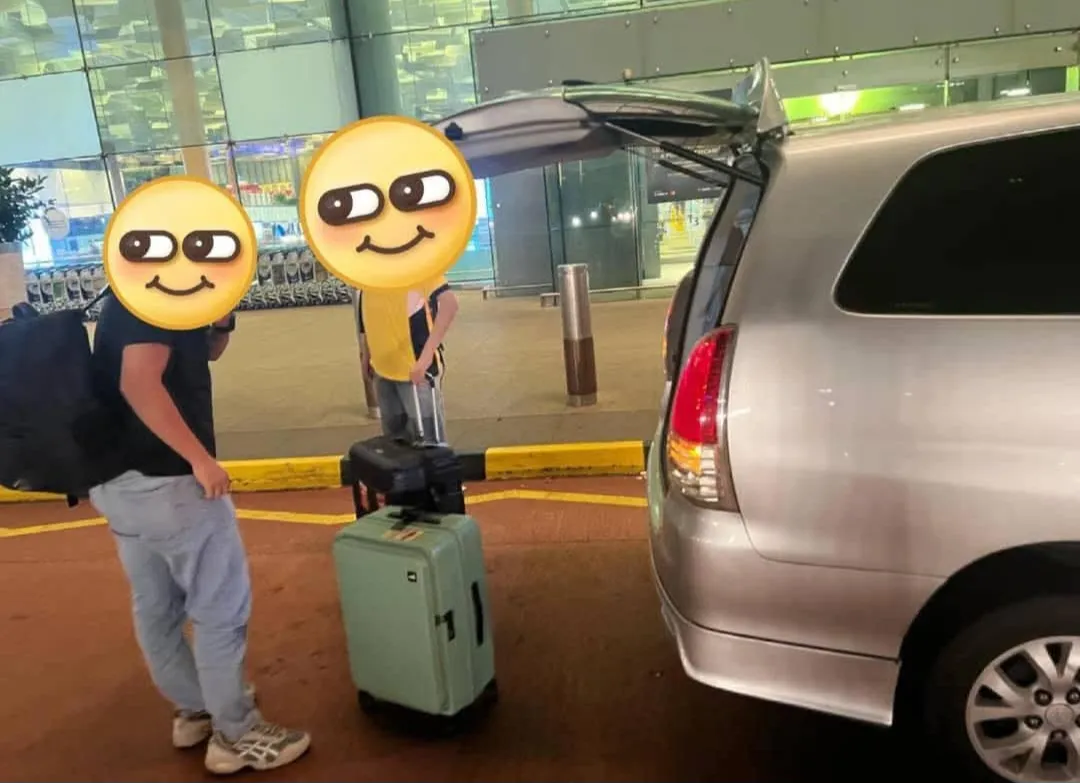 Customers with luggage beside a silver van at a terminal building