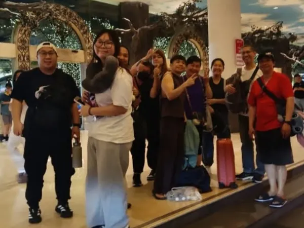 A group posing in a decorated hotel lobby with luggage