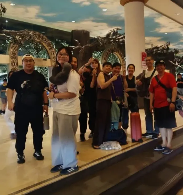 A group posing in a decorated hotel lobby with luggage