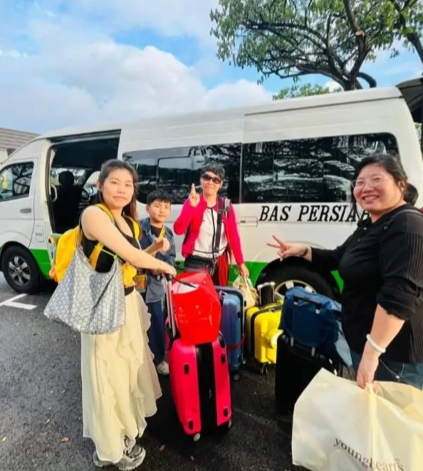 A family with luggage beside a Bas Persiaran tour van