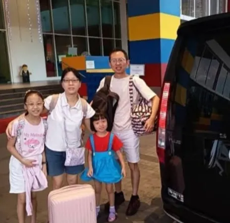 A family of four outside the Legoland Hotel entrance beside a black MPV