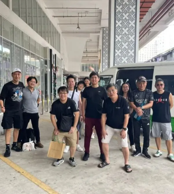 A group of customers with their chauffeur van outside a building in Malaysia