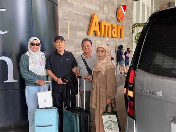A family posing with their Hyundai Starex chauffeur van outside the Amari hotel