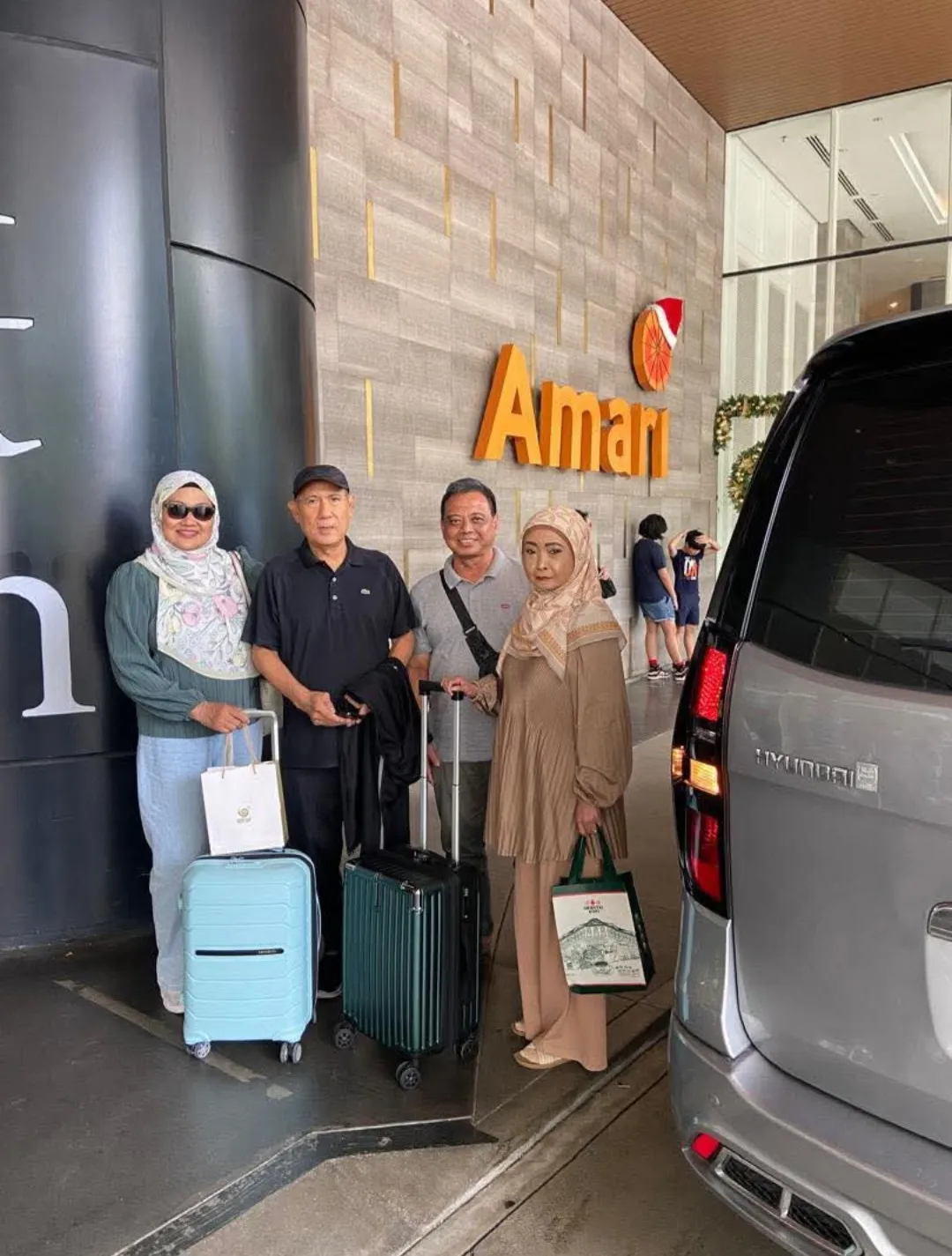 A family posing with their Hyundai Starex chauffeur van outside the Amari hotel