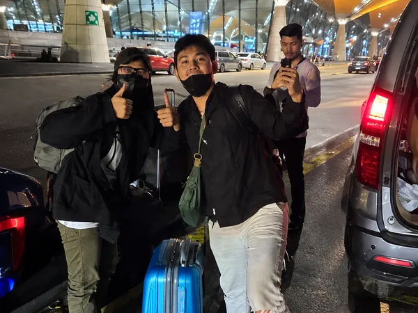 Two customers with luggage at Kuala Lumpur International Airport at night